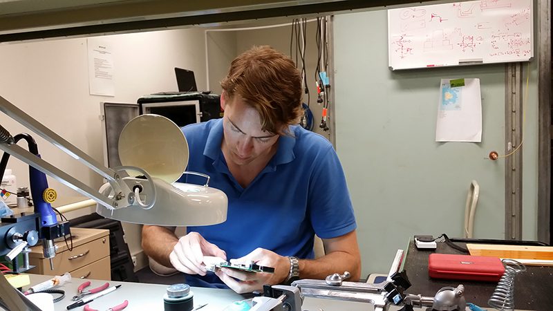 Electrical engineering and computing student, Shane Overington, working in the ICRAR electronic laboratory to diagnose and repair a faulty MWA data transmission printed circuit board.