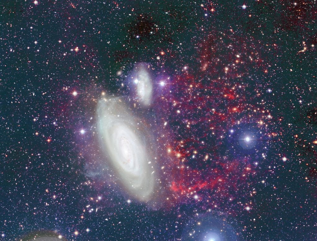 The foreground galaxy is NGC 4569 of the Virgo cluster. The red filaments at the right of the galaxy show the hydrogen gas that has been removed. The tail represents about 95 per cent of the gas reservoir the galaxy needs to feed the formation of new stars. Credit: CFHT/Coelum
