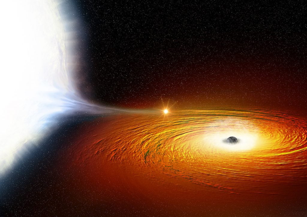 An artist’s impression of a white dwarf star (left) in orbit around a black hole and so close that much of its material is being pulled away. There is a hotspot where the gas from the white dwarf hits the disc of matter swirling around the black hole. The black hole itself is surrounded by a cloud of ionised gas, which contains large amounts of oxygen. Credit: X-ray: NASA/CXC/University of Alberta/A.Bahramian et al.; Illustration: NASA/CXC/M.Weiss.