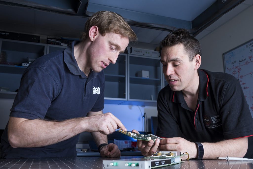Sascha Schediwy and David Gozzard with components of their SKA-mid phase synchronisation system Transmitter Module. Credit: ICRAR.