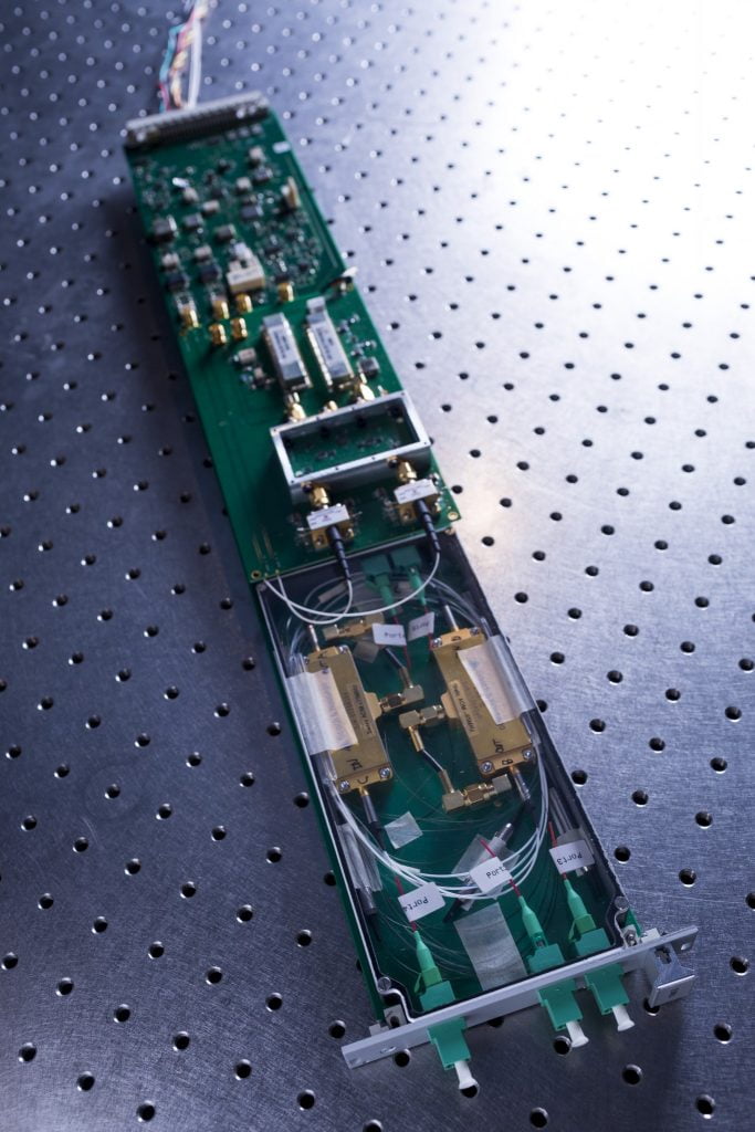 A prototype Transmitter Module showing the fibre-optic components in the foreground, the electronic microwave-frequency mixing circuitry in the middle, and stabilisation electronics at the rear. The SKA-mid synchronisation system will comprise 197 of these modules.Credit: ICRAR.