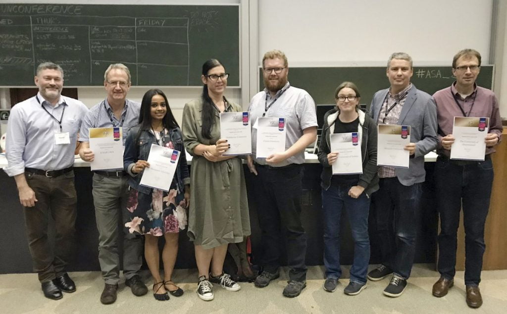 Row of astronomers holding their Pleiades certificates.
