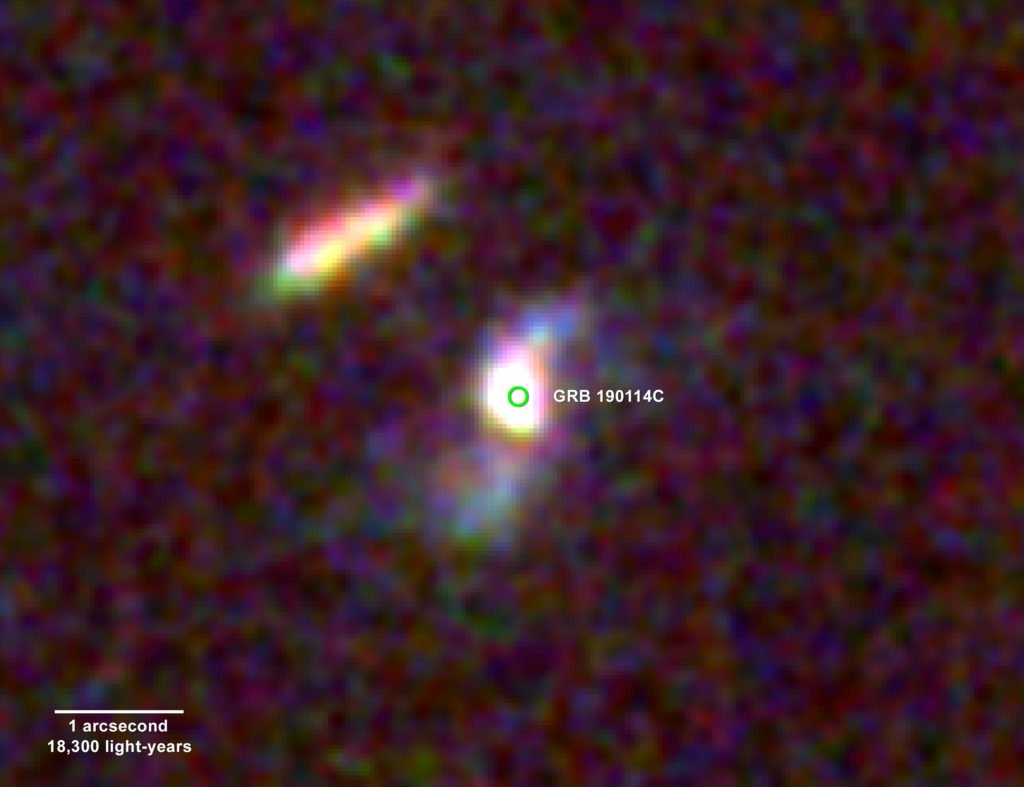 The fading afterglow of GRB 190114C and its home galaxy were imaged by the Hubble Space Telescope on Feb. 11 and March 12, 2019. The difference between these images reveals a faint, short-lived glow (centre of the green circle) located about 800 light-years from the galaxy’s core. Blue colours beyond the core signal the presence of hot, young stars, indicating that this is a spiral galaxy somewhat similar to our own. It is located about 4.5 billion light-years away in the constellation Fornax. Credit: NASA, ESA, and V. Acciari et al. 2019