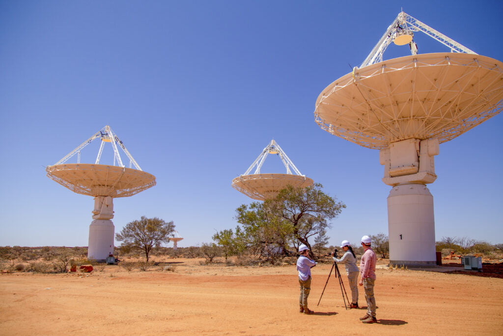 The White Spark Pictures crew (Briege Whitehead, Jess Black and Ben Ellard) filming amongst several of the 36 dish antennas that belong to CSIRO's Australian SKA Pathfinder.