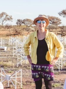 Dr Natasha Hurley-Walker on-site at CSIRO's Murchison Radio-astronomy Observatory, standing amongst the core 'tiles' of the Murchison Widefiled Array.