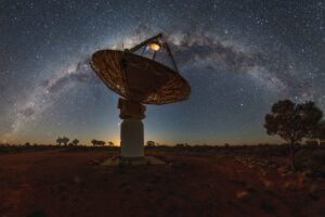 Starry night with a silhouette of a telescope dish